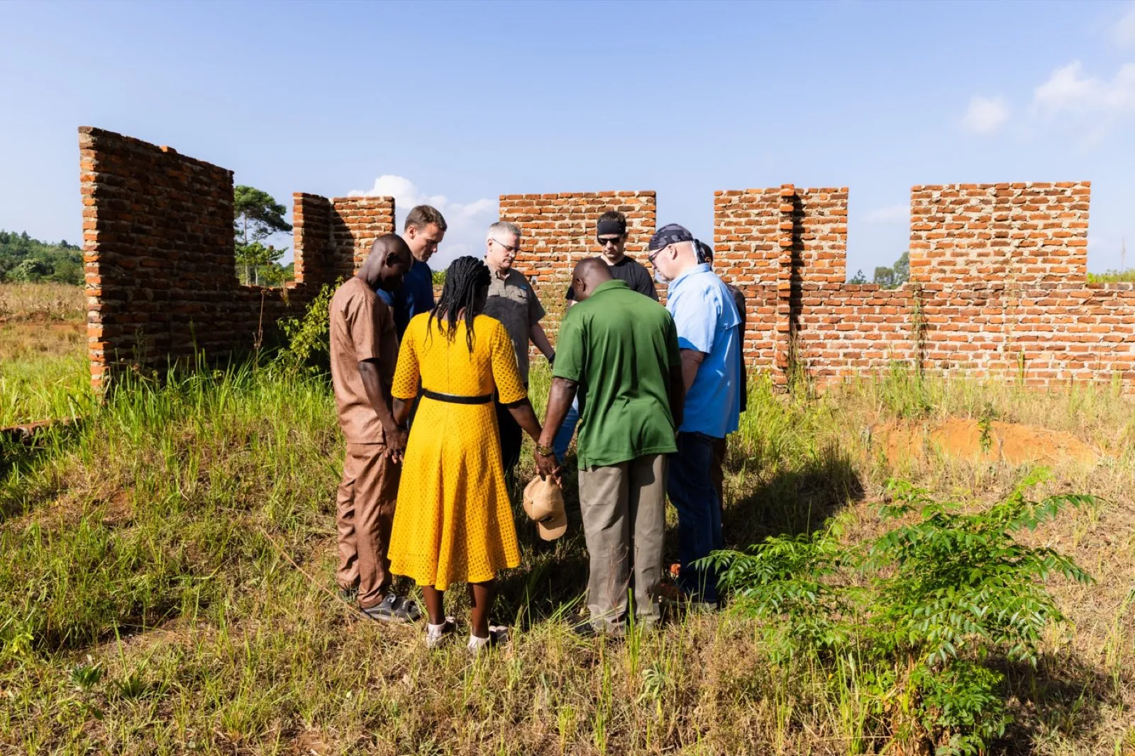 Group praying at construction site, Africa mission trip 2026
